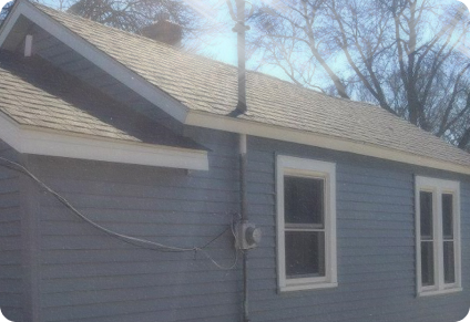 the side of a home remodeled with a new roof and new siding from the 2000's