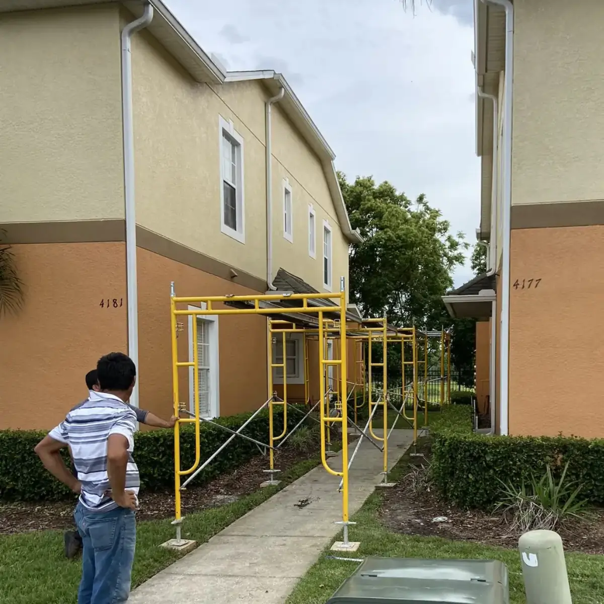 Scaffolded pedestrian route between buildings during Central Florida shingle replacement.