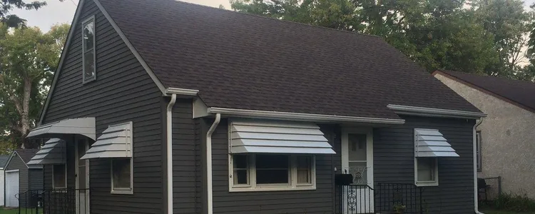 Charcoal fiber cement siding and a new roof on a finished Blaine home, shot from the yard.