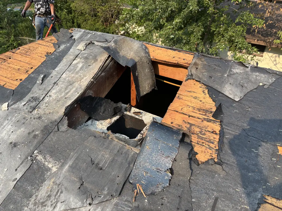 Roof tear-off in progress on a Minneapolis home with decking and an old opening exposed.