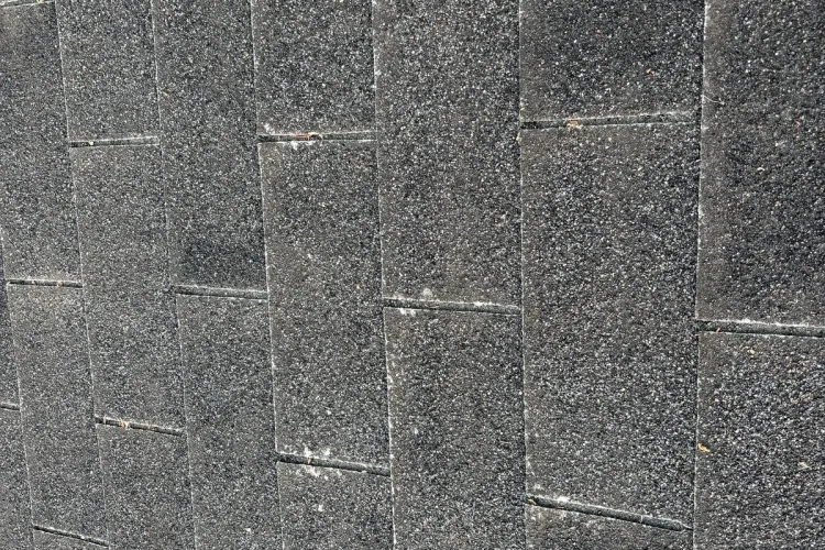 Close-up of weathered asphalt shingles on a Minneapolis roof before replacement.