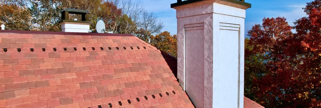 Chimney with a metal cap and flashing on a new DaVinci synthetic slate roof