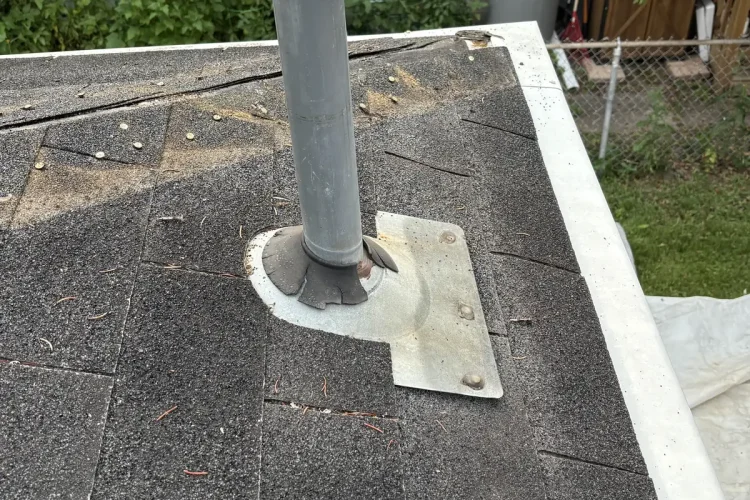 Plumbing vent pipe and metal boot on a low-slope section of a Minneapolis roof.