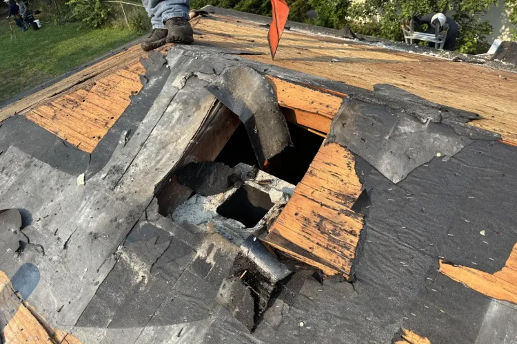 Old roofing layers and decking exposed during a Minneapolis roof tear-off.