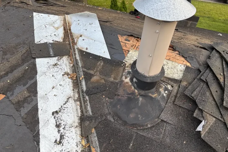 Old roof vent and flashing exposed after shingles were pulled back on a Minneapolis roof.